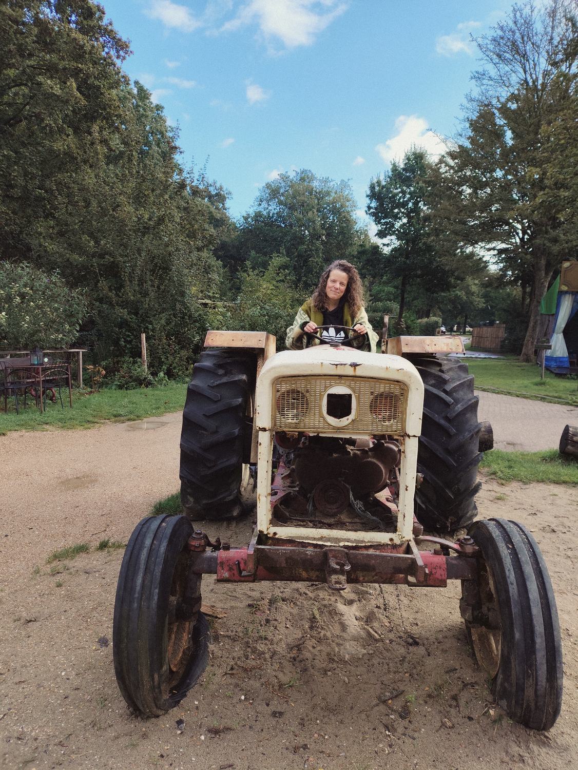 Anneke achter het stuur van een oude tractor